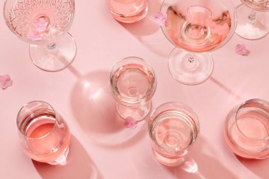 Pembe arka planda çeşitli pembe bardaklar, üst manzara.