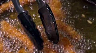 kızgın yağda kızaran ekmeklenmiş karidesler, lezzetli atıştırmalıklar yapma süreci, yakın plan yiyecekler.