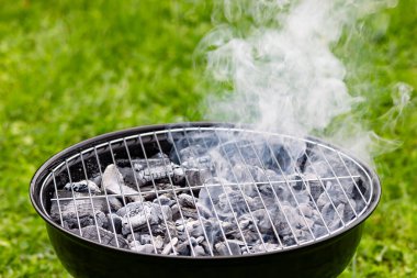 Bahçede dumanlı boş ızgara.