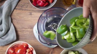 Aşçı sağlıklı gazpacho çorbası yapmak için karıştırıcıya dilimlenmiş dolmalık biber koyar.