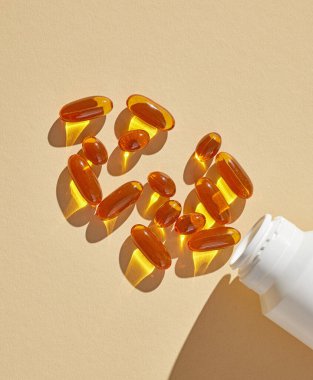Bej arka planda vitamin yağı kapsülleri, üst görünüm