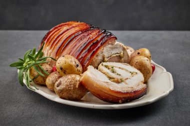 Mükemmel domuz rostosu ve fırında patates, gri arka plan.