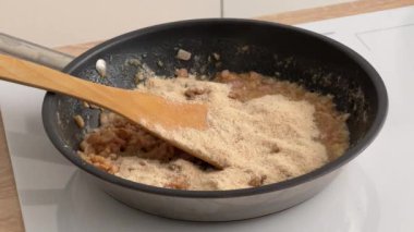 Aşçı mutfakta ekmek kırıntıları ve erimiş tereyağlı domuz pastırması karıştırıyor. Ev yapımı yemek yapma, evde yemek pişirme, yakın çekim.