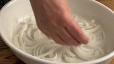 Aşçı mutfaktaki ahşap tahtaya taze doğranmış soğan koydu. Ev yapımı yemek yapma, evde yemek pişirme, yakın plan yemek, domuz rostosu pişirme. 