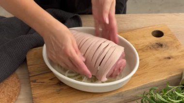 Aşçı domuz pirzolasını ekmek kırıntıları, pastırma ve tereyağını mutfak tahtasındaki ahşap tabağa koydu. Ev yapımı yemek yapma, evde yemek pişirme, yakın plan yemek, domuz rostosu pişirme.