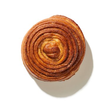 Beyaz arka planda izole edilmiş taze pişmiş tatlı tarçınlı rulo.