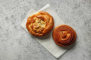 Gri masada taze pişmiş tatlı ekmek ruloları, üst manzara.