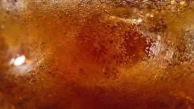 Buzlu bardağa dökülen taze kolayı kapat. Baloncuklar buz küplerinin etrafında hareket eder makro