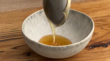 Aşçı kadın mutfaktaki tahta tahtaya bal döktü. Ev yapımı yemek yapma, evde yemek pişirme, yakın plan yemek, jöleli domuz rostosu pişirme.