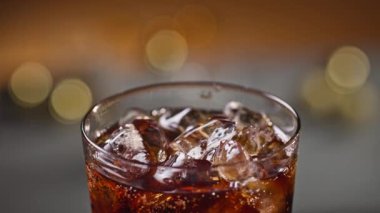 Buzlu bardakta taze kola, yakın çekim. Odaklanamayan şenlik arkaplanı