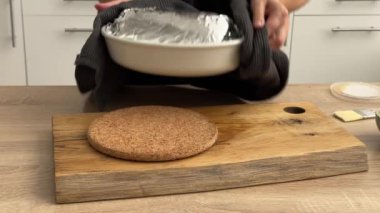 Aşçı kadın domuz pirzolasını fırından çıkarıp mutfaktaki ahşap tahtaya koyar. Ev yapımı yemek yapma, evde yemek pişirme, yakın plan yemek, domuz rostosu pişirme.