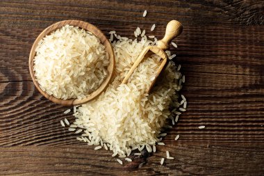 Ahşap mutfak masasında çiğ pirinç, üst manzara.