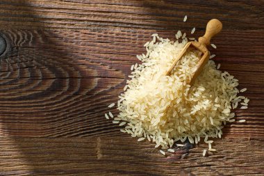 Ahşap mutfak masasında çiğ pirinç, üst manzara.