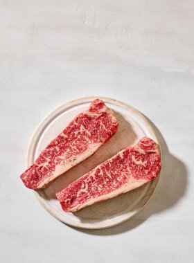 Taze çiğ Avustralya Wagyu bifteği açık güneşli mutfak masası yüzeyinde, üst manzara.