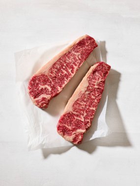 Taze çiğ Avustralya Wagyu bifteği açık güneşli mutfak masası yüzeyinde, üst manzara.