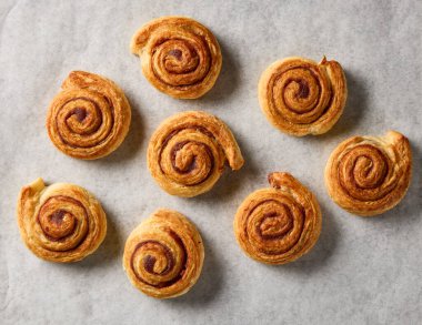 Yeni pişmiş tarçınlı rulo, kabartma kağıdının üstünde.