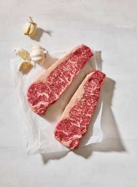 Taze çiğ Avustralya Wagyu bifteği açık güneşli mutfak masası yüzeyinde, üst manzara.