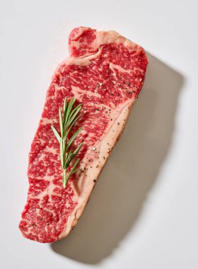 Taze çiğ Avustralya Wagyu bifteği açık güneşli mutfak masası yüzeyinde, üst manzara.