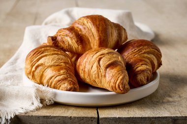 Ahşap kırsal mutfak masasında yeni pişmiş kruvasanlar.