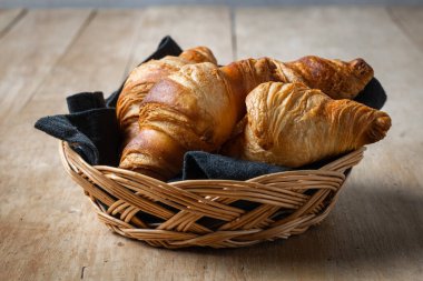 Ahşap kırsal mutfak masasında yeni pişmiş kruvasanlar.