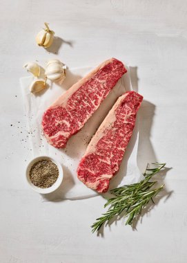 Taze çiğ Avustralya Wagyu bifteği açık güneşli mutfak masası yüzeyinde, üst manzara.