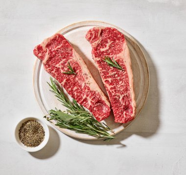 Taze çiğ Avustralya Wagyu bifteği açık güneşli mutfak masası yüzeyinde, üst manzara.