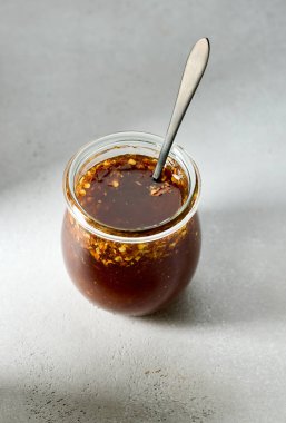 Beyaz mutfak masasında cam kavanozda sıcak bal sosu.