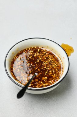 Beyaz mutfak masasında bir kase sıcak bal sosu.