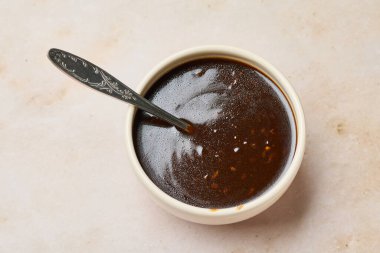 Bej mutfak masasında bir kase Çin sarımsak sosu.