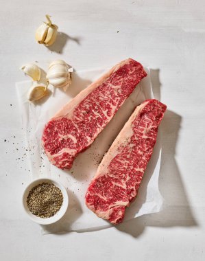 Taze çiğ Avustralya Wagyu bifteği açık güneşli mutfak masası yüzeyinde, üst manzara.