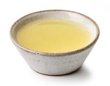 Beyaz arka planda izole edilmiş bir kase taze limon suyu.