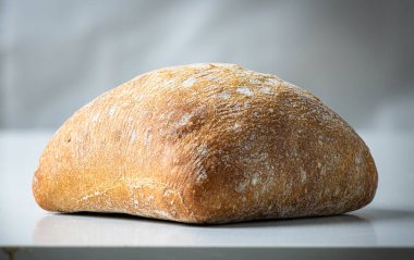 Gri arkaplanda taze pişmiş ciabatta ekmeği.