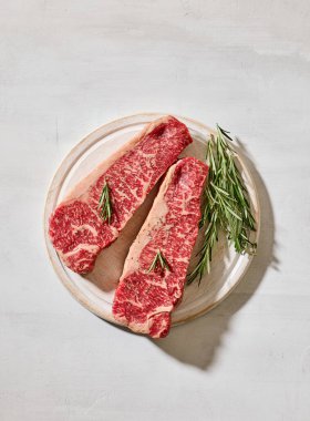 Taze çiğ Avustralya Wagyu bifteği açık güneşli mutfak masası yüzeyinde, üst manzara.