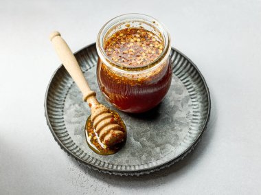 Beyaz mutfak masasında bir kavanoz sıcak bal sosu.