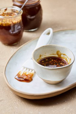 Bej mutfak masasında bir kase sıcak bal sosu.