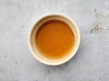 Gri mutfak masasında bir kase susam yağı, üst manzara.