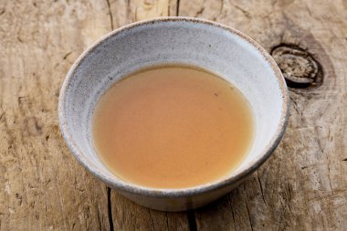 Kırsal ahşap mutfak masasında bir kase susam yağı.