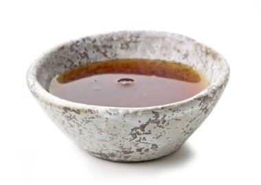 Beyaz arkaplanda izole edilmiş küçük bir akçaağaç şurubu kasesi, seçici odaklanma