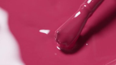 Pembe tırnak cilası arkaplan ve pürüzsüz dokuyu gösteren bir fırça, yakın çekim makrosu, üst görünüm