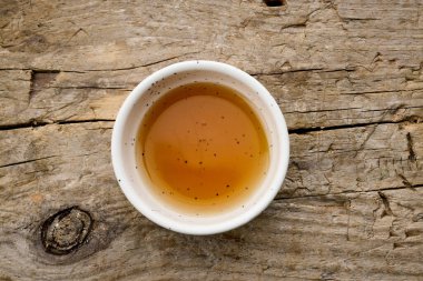 Kırsal ahşap mutfak masasında bir kase susam yağı.