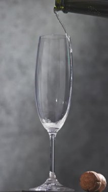 Gri arkaplandan dökülen taze şampanya, yakın plan.