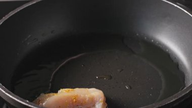 Aşçı lezzetli, sağlıklı yemek ve yakın çekim hazırlamak için tavaya baharatlı fileto koydu.