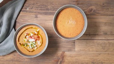 Aşçı kaseye gazpacho çorbası dök ve doğranmış sebze ekle. Taze soğuk domates çorbası yapma süreci. Yemekler yakın çekim, üst manzara