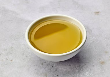 Gri masa arkasında bir kase zeytinyağı