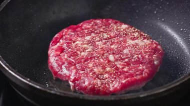 Taze çiğ kırmızı et burger köftesi sıcak tavada pişer, yemek yakın plan, zoom