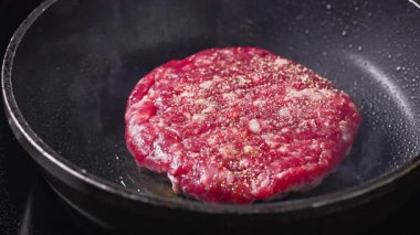 Aşçı etrafında döner taze kırmızı et burger et köfte sıcak tavada pişirme, yiyecek yakın çekim