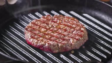 Sulu burger üzerine biber serpiştirmek ızgara tavada pişirmek, yakın plan yemek