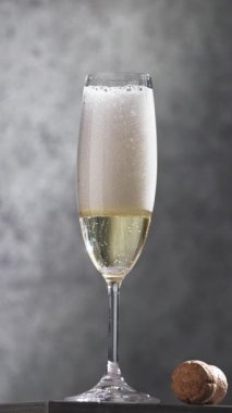 Gri arka planda taze şampanya, yakın plan.