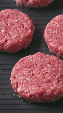 Şef taze et köftelerini pişirmek için elektrikli ızgaraya koyar, yemekleri de yakın plan yapar.