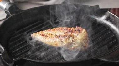Aşçı, sağlıklı bir yemek hazırlamak için tavuklu fileto pişiriyor. Yemekler yakın plan.